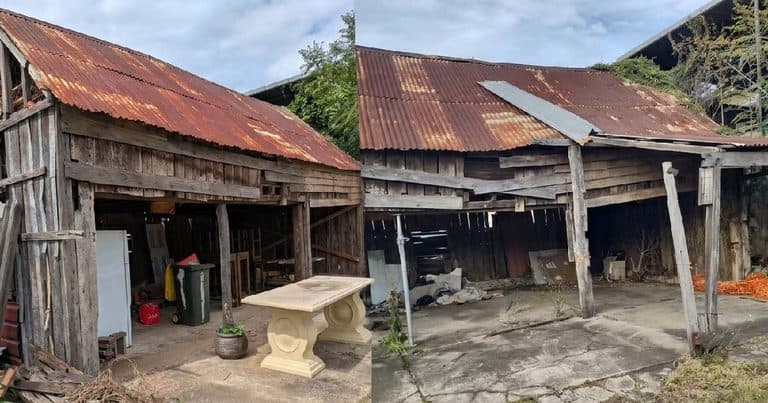 Old wooden shed with rusted metal roof in rural area.