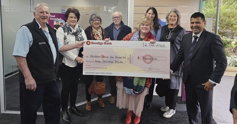 Group of people holding a large check at Bendigo Bank event.