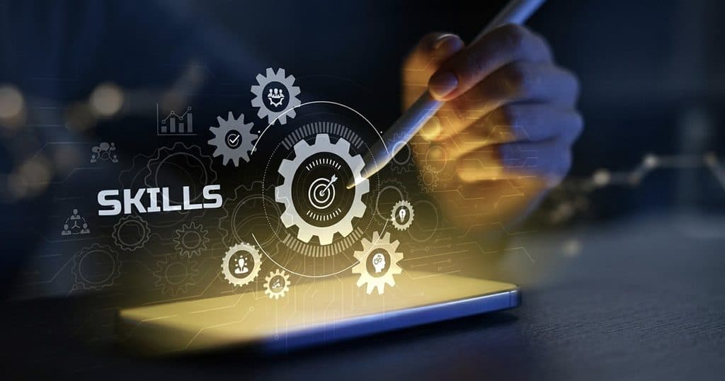 Skills development concept with gears and digital technology on a touchscreen.