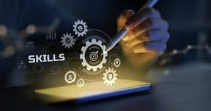 Skills development concept with gears and digital technology on a touchscreen.